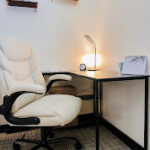 View from the doorway into Alexis Lynne Jardine's cozy therapy room, showing the sofa, armchair, and natural light.