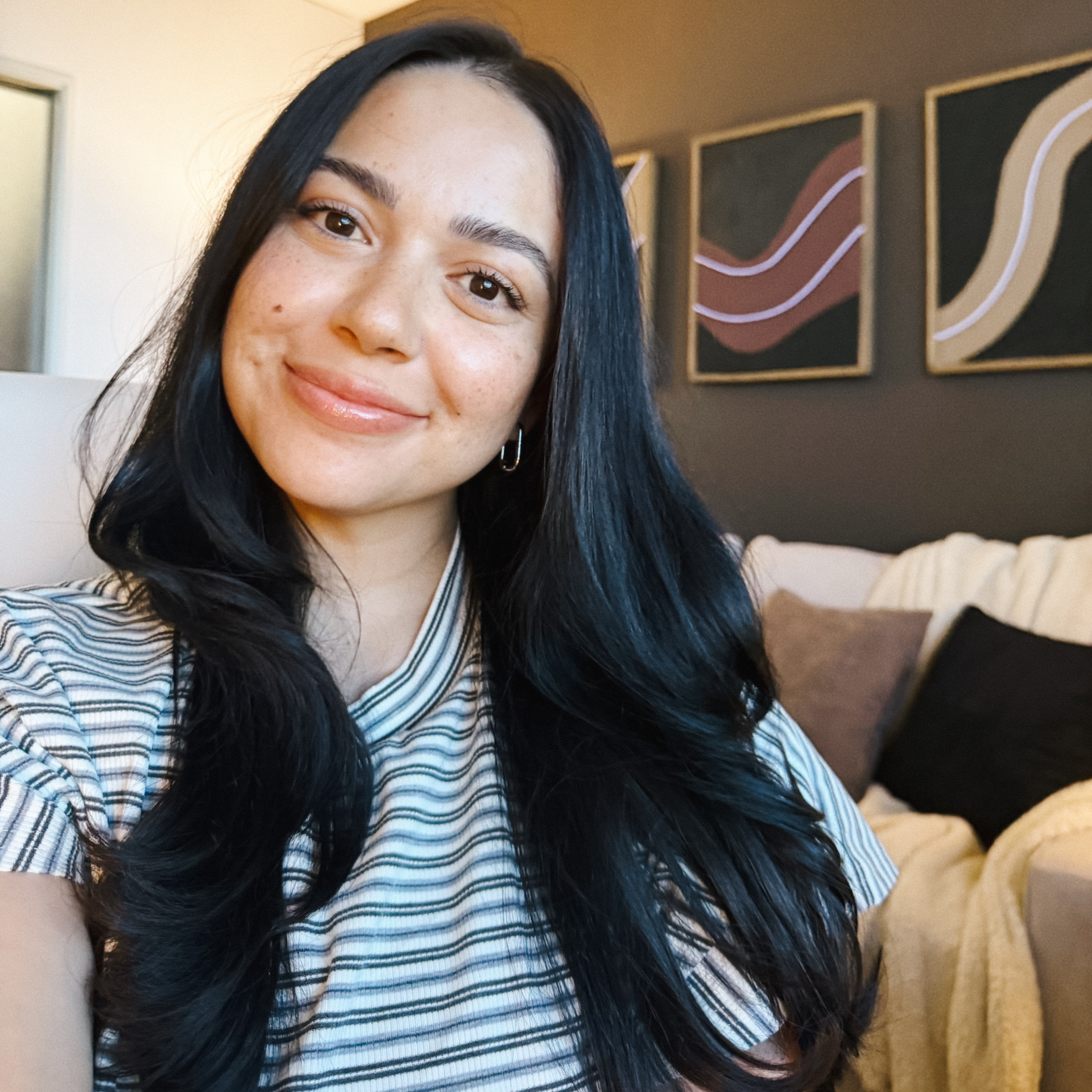 Smiling brunette woman with striped shirt in office setting, therapyworthwhile