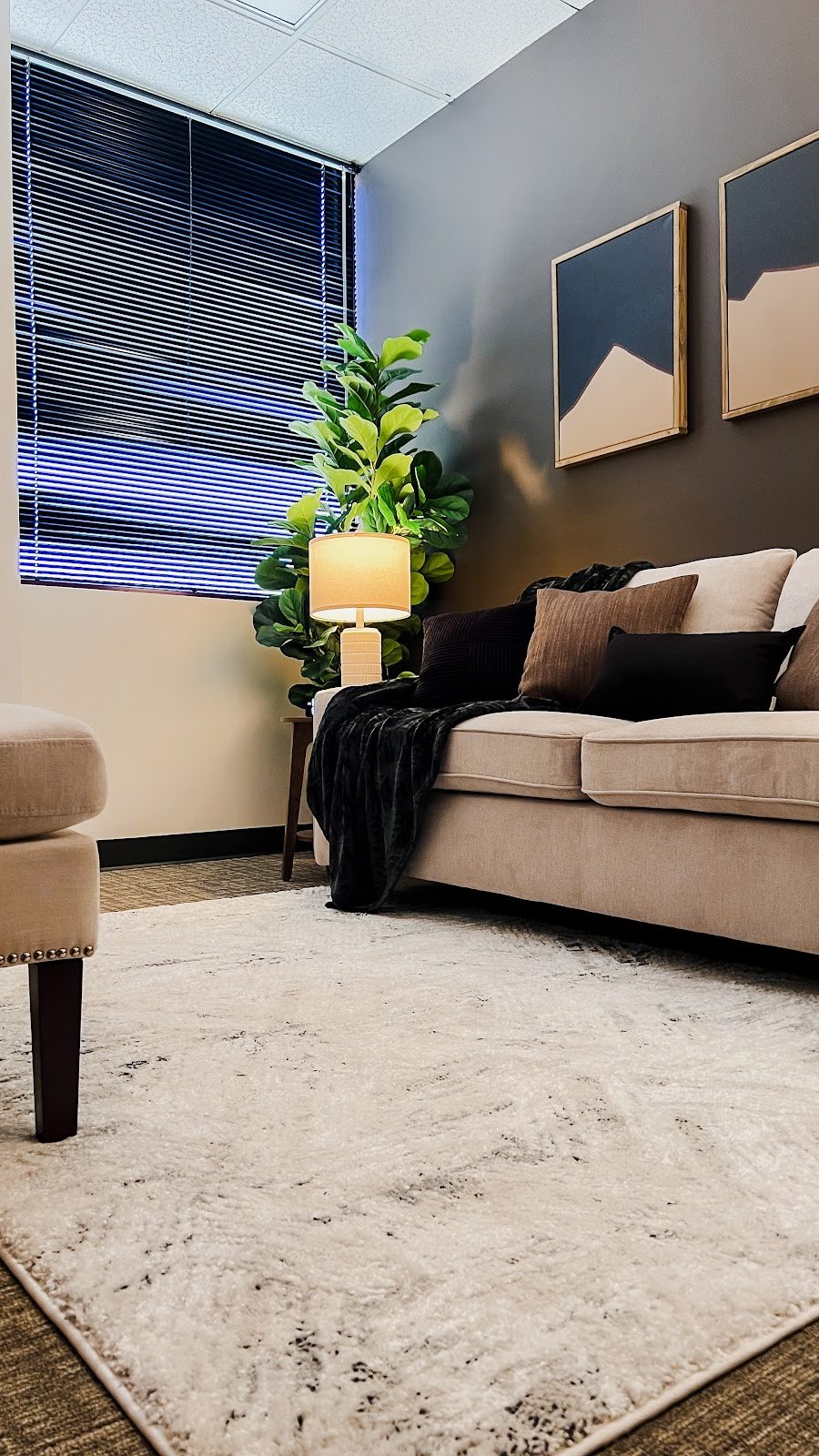 Modern therapy therapy room of Therapy Worthwhile featuring a comfortable sofa, cream rug, and earth tone pillows